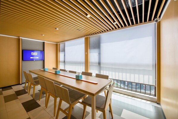 A conference room with a long table, chairs, a television, and large windows with a view. - Holiday Inn Express Foshan Chancheng (Foshan)