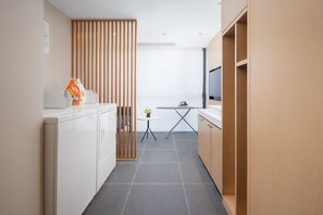 A modern kitchen with a dining area, a small table, and a TV.