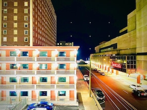 A hotel with multiple floors, a visible entrance, and a street view with cars and a building with a sign. - Clarion Inn Atlantic City - Beach and Boardwalk (Atlantic City)