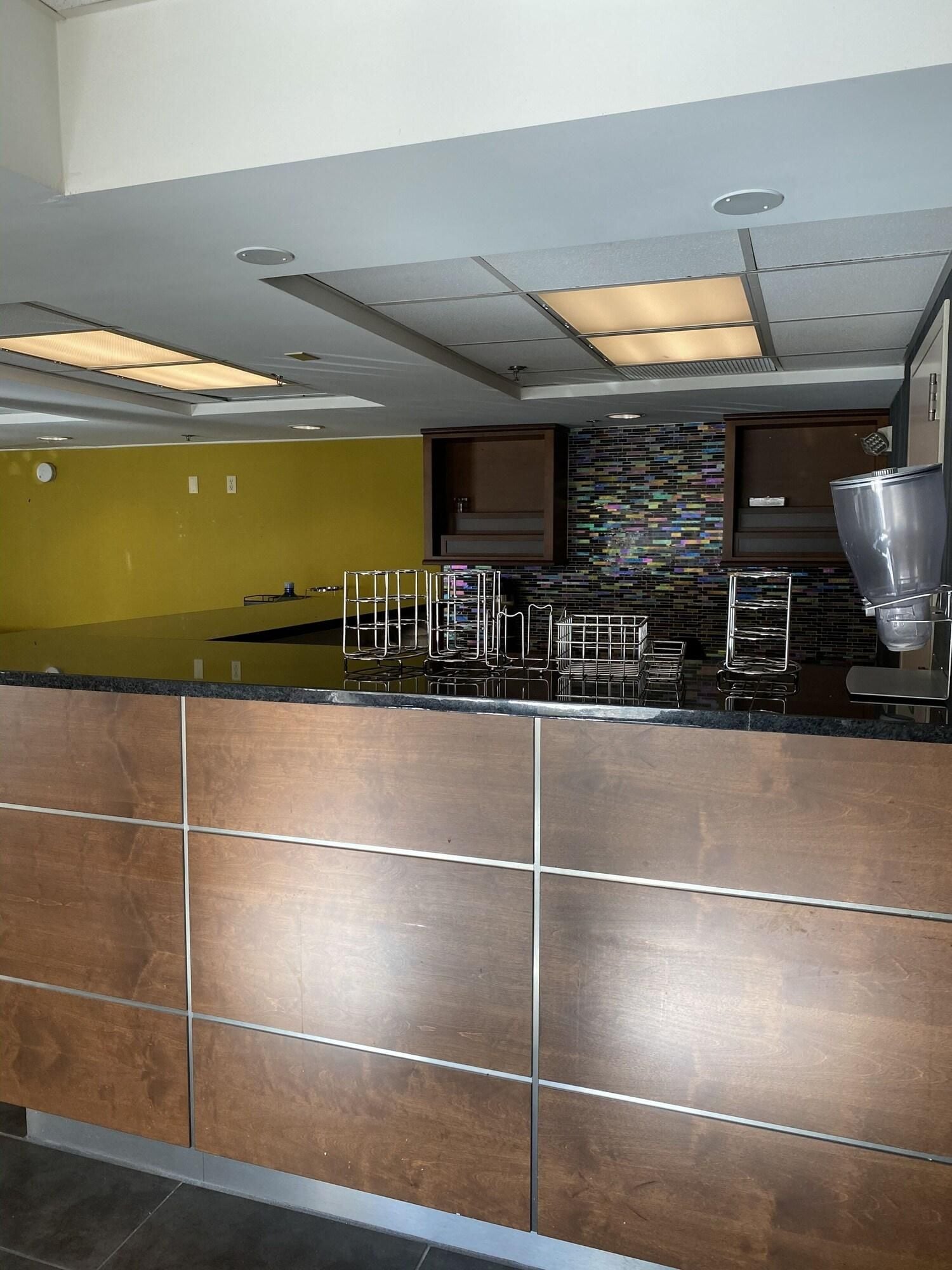 A modern kitchen with a black countertop, stainless steel appliances, and a tiled backsplash.