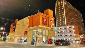 A hotel with a prominent Clarion Inn sign, a visible speed limit sign, and a street intersection with traffic lights. - Clarion Inn Atlantic City - Beach and Boardwalk (Atlantic City)