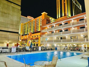 A hotel pool area with multiple levels of balconies, a sign for Tropicana, and a notice about no lifeguard on duty. - Clarion Inn Atlantic City - Beach and Boardwalk (Atlantic City)