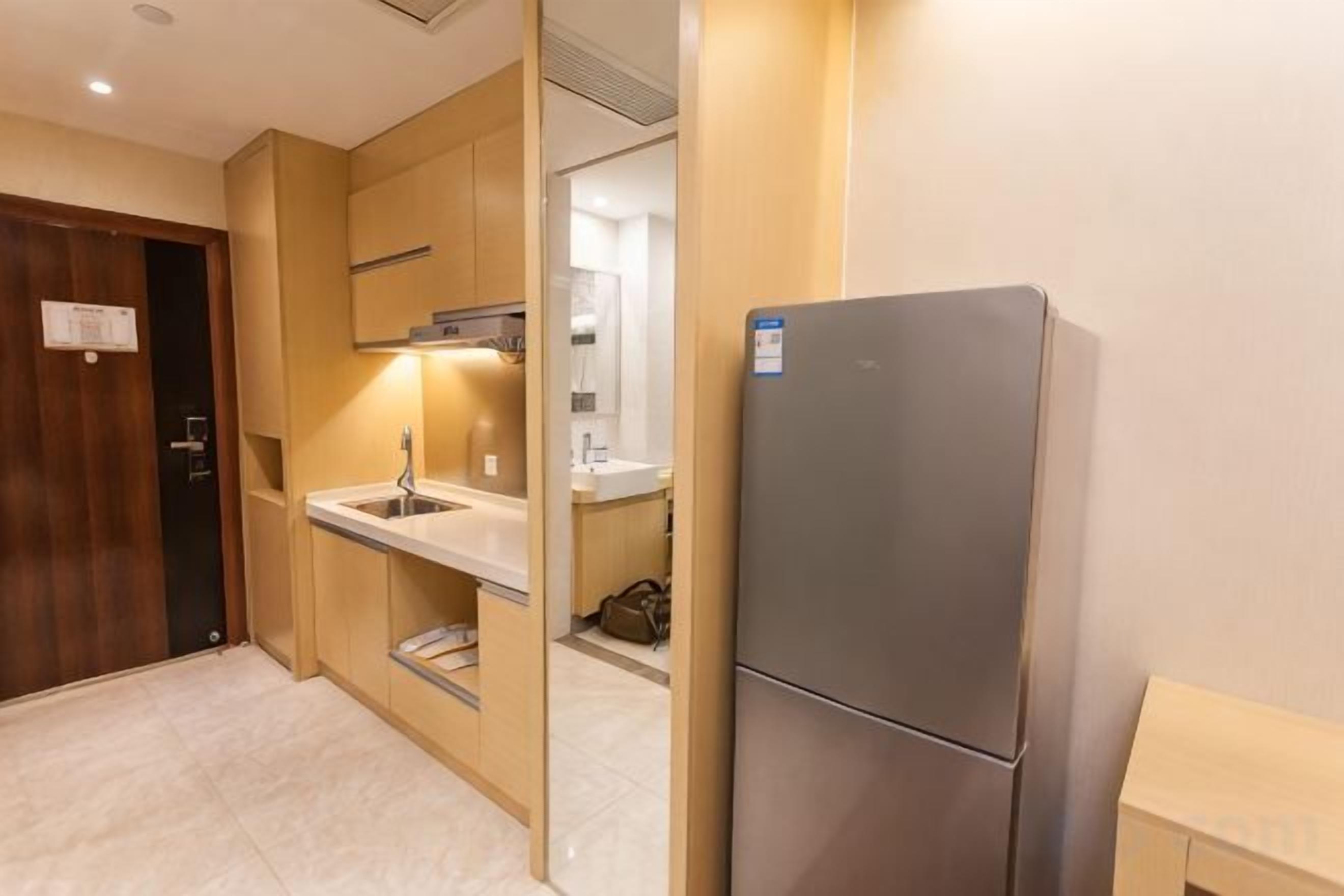 A compact kitchen with a built-in refrigerator, a sink, and a microwave.