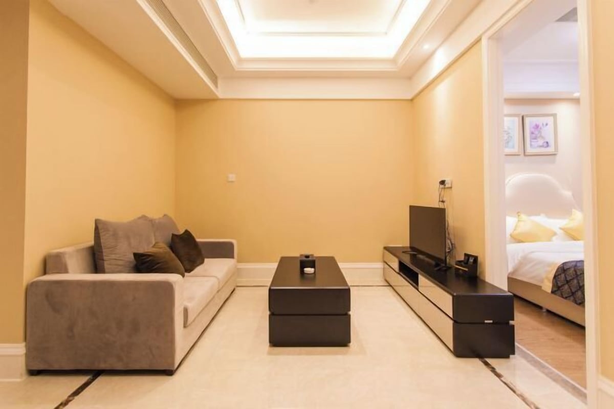 Ein modernes Wohnzimmer mit einer Couch, einem Couchtisch und einer TV-Konsole.