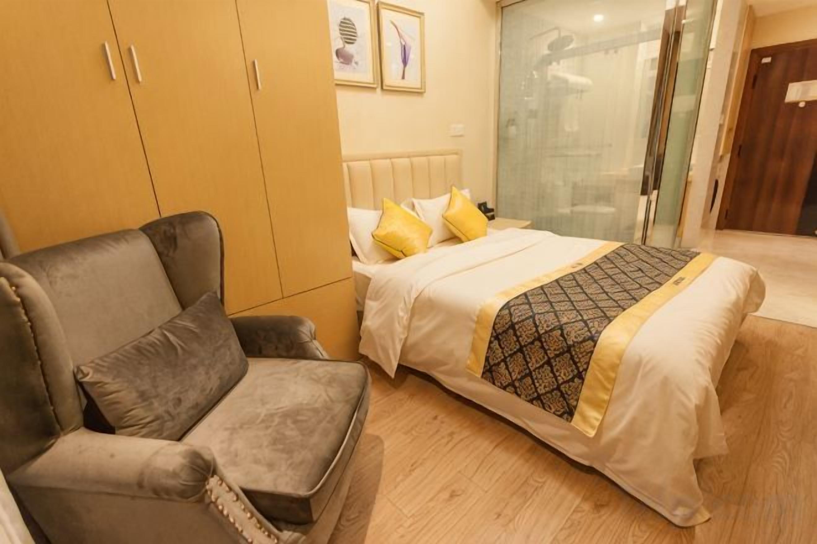 A bedroom with a bed, a sofa, and a wardrobe.