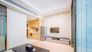 A modern kitchen with wooden cabinets, a refrigerator, and a built-in oven. - Sweetome Boutique Apartment (Yangzhou Railway Station Jinghua City) (Yangzhou)