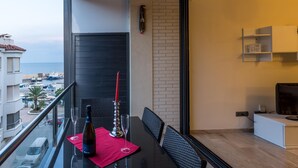Un balcón con una mesa para dos, una botella de vino y una vela.