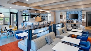 Un moderno vestíbulo de hotel con zonas de estar, un bar y una cocina.