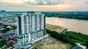 Un hotel moderno de gran altura con varios pisos, un aparcamiento y vistas al río.