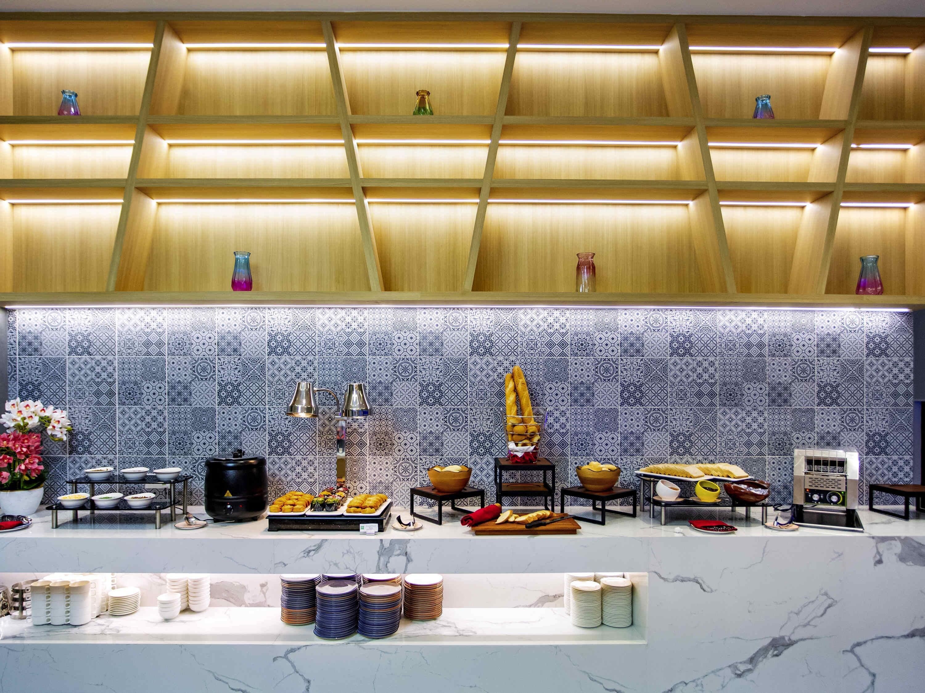 Montaje de bufé con diversos alimentos y un revoque de azulejos.
