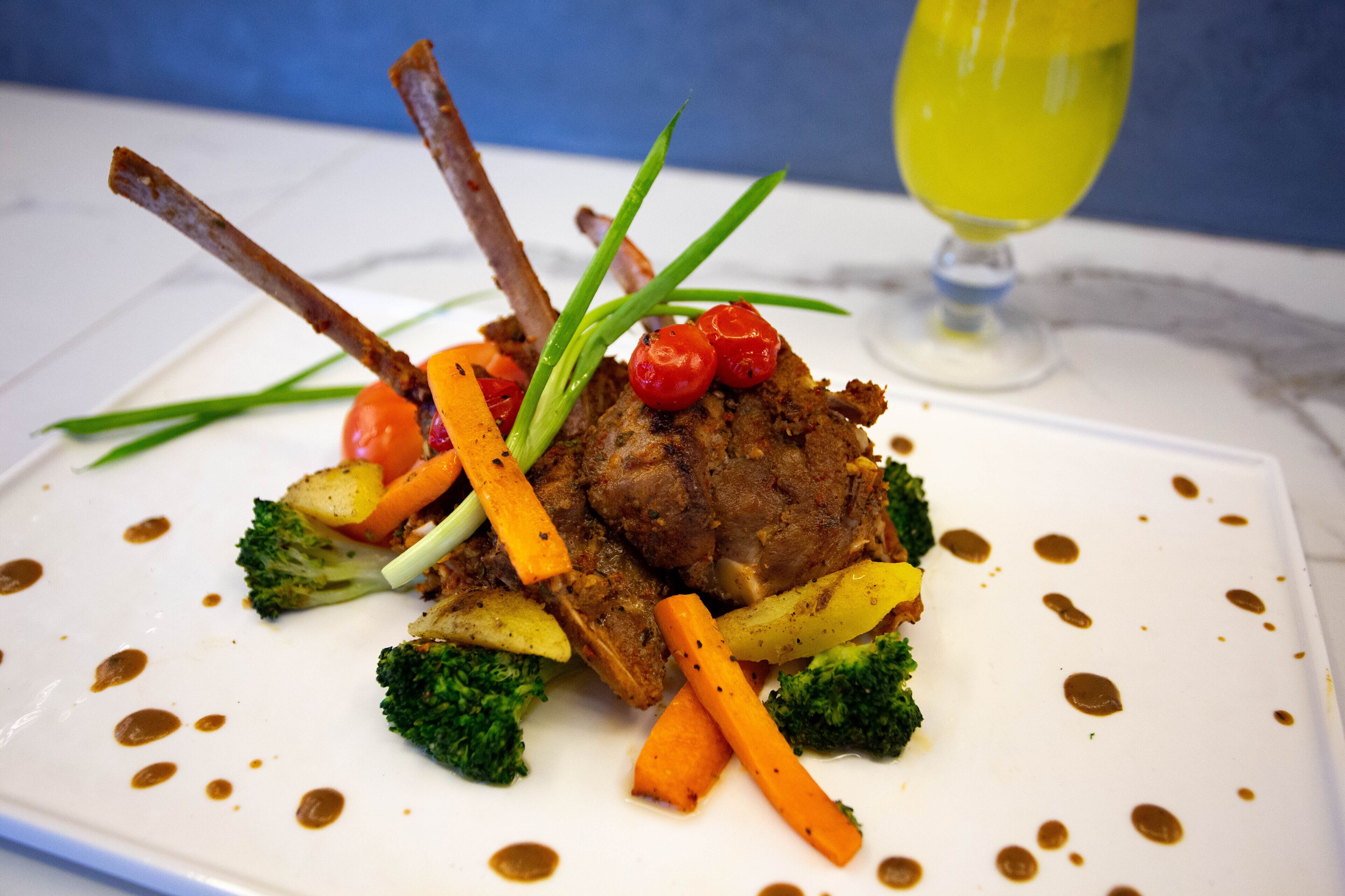 Un plato con carne, verduras y salsa.