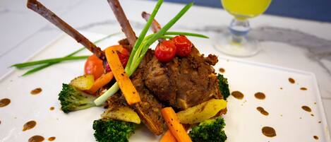 Un plato con carne, verduras y salsa.