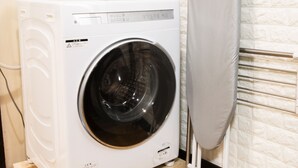 A front-loading washing machine in a laundry room with a tiled wall and a metal towel rack. - Within walking distance to Shinjuku | 4 min walk to nearest station | Entire 3BR house 75㎡ | Sleeps up to 10 | Family-friendly | High-speed Wi-Fi | Shibuya, Tokyo (Tokyo)
