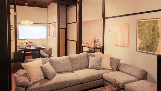 A modern living room with a sectional sofa, a dining table with chairs, and artwork on the walls. - Within walking distance to Shinjuku | 4 min walk to nearest station | Entire 3BR house 75㎡ | Sleeps up to 10 | Family-friendly | High-speed Wi-Fi | Shibuya, Tokyo (Tokyo)