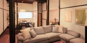 A modern living room with a sectional sofa, a dining table with chairs, and artwork on the walls. - Within walking distance to Shinjuku | 4 min walk to nearest station | Entire 3BR house 75㎡ | Sleeps up to 10 | Family-friendly | High-speed Wi-Fi | Shibuya, Tokyo (Shibuya-ku)