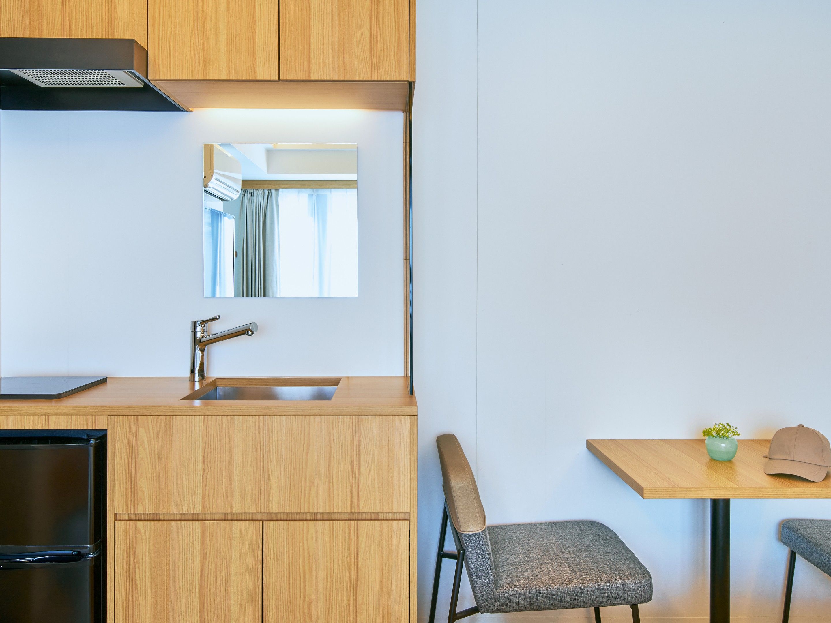 A modern kitchen with wooden cabinets, a stainless steel sink, and a built-in oven.