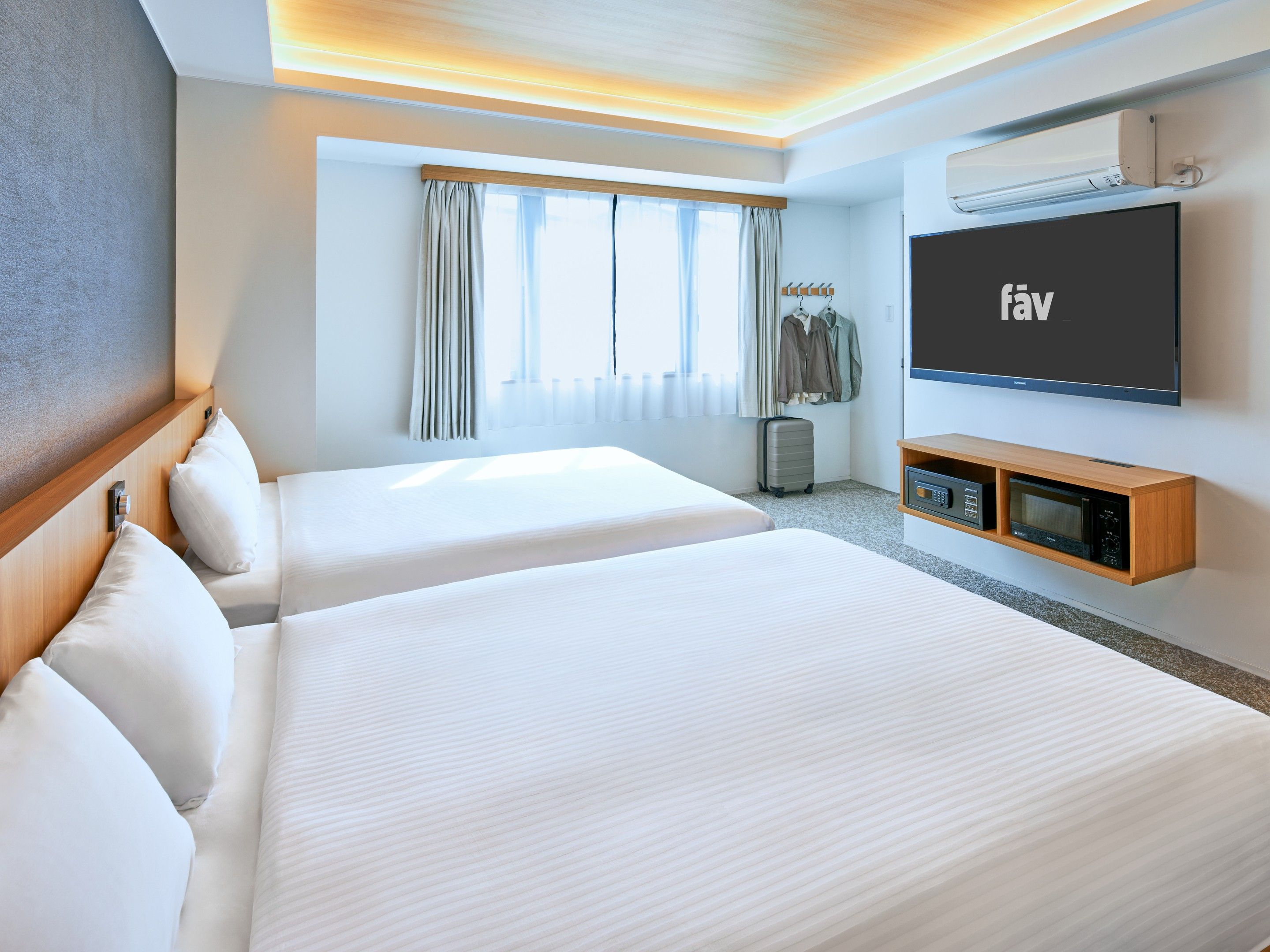 Habitación de hotel con dos camas, un televisor de pantalla plana, un minibar y un ventanal con cortinas.