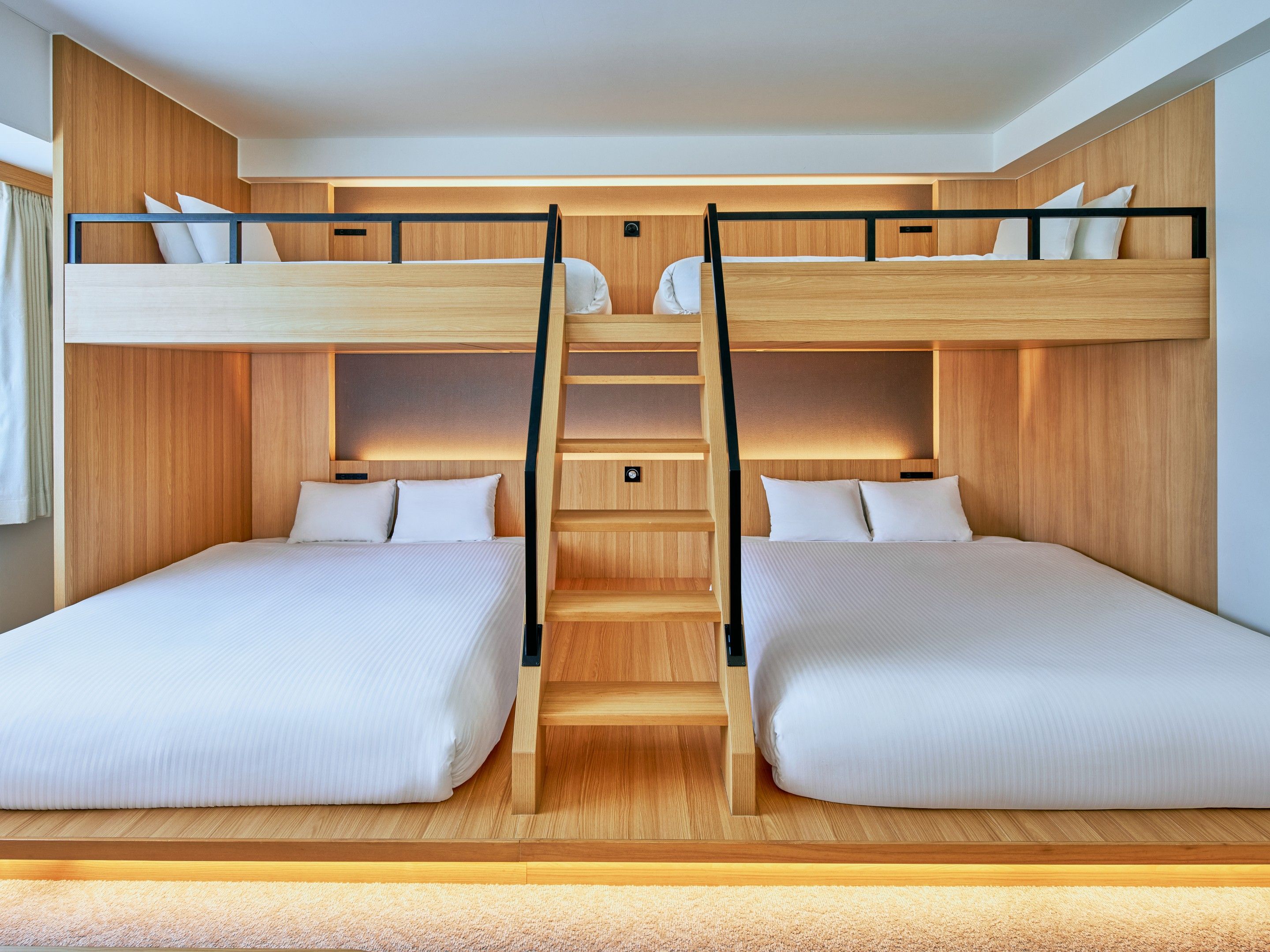 A bunk bed room with a wooden interior, two beds, a ladder, and a small shelf.