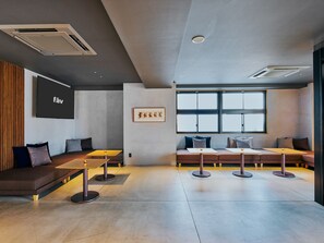 A modern interior with a seating area, tables, and a large window providing natural light. - fav HIDATAKAYAMA (Takayama)