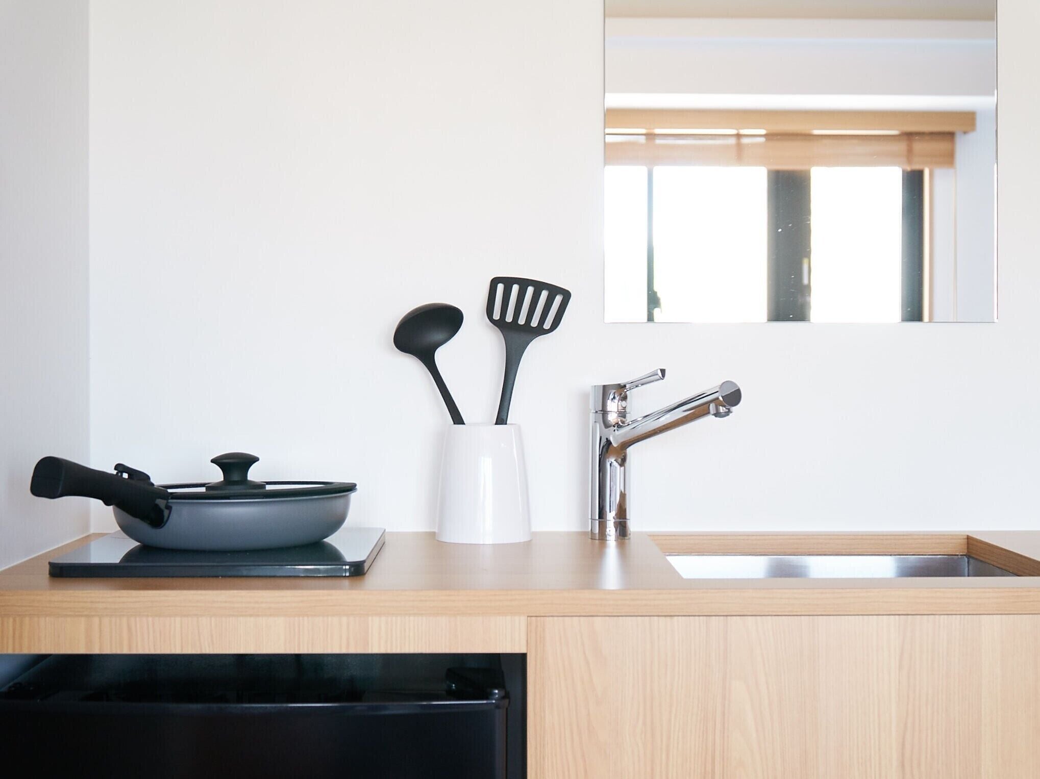 Una cocina moderna con un lavabo, una estufa y una ventana.