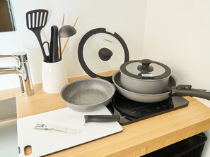 A kitchen counter with a stove, a frying pan, a pot, a spatula, and a knife. - fav HIDATAKAYAMA (Takayama)