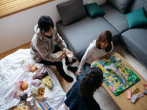A room with a grey sofa, a wooden coffee table, and a blanket on the floor. - fav HIDATAKAYAMA (Takayama)