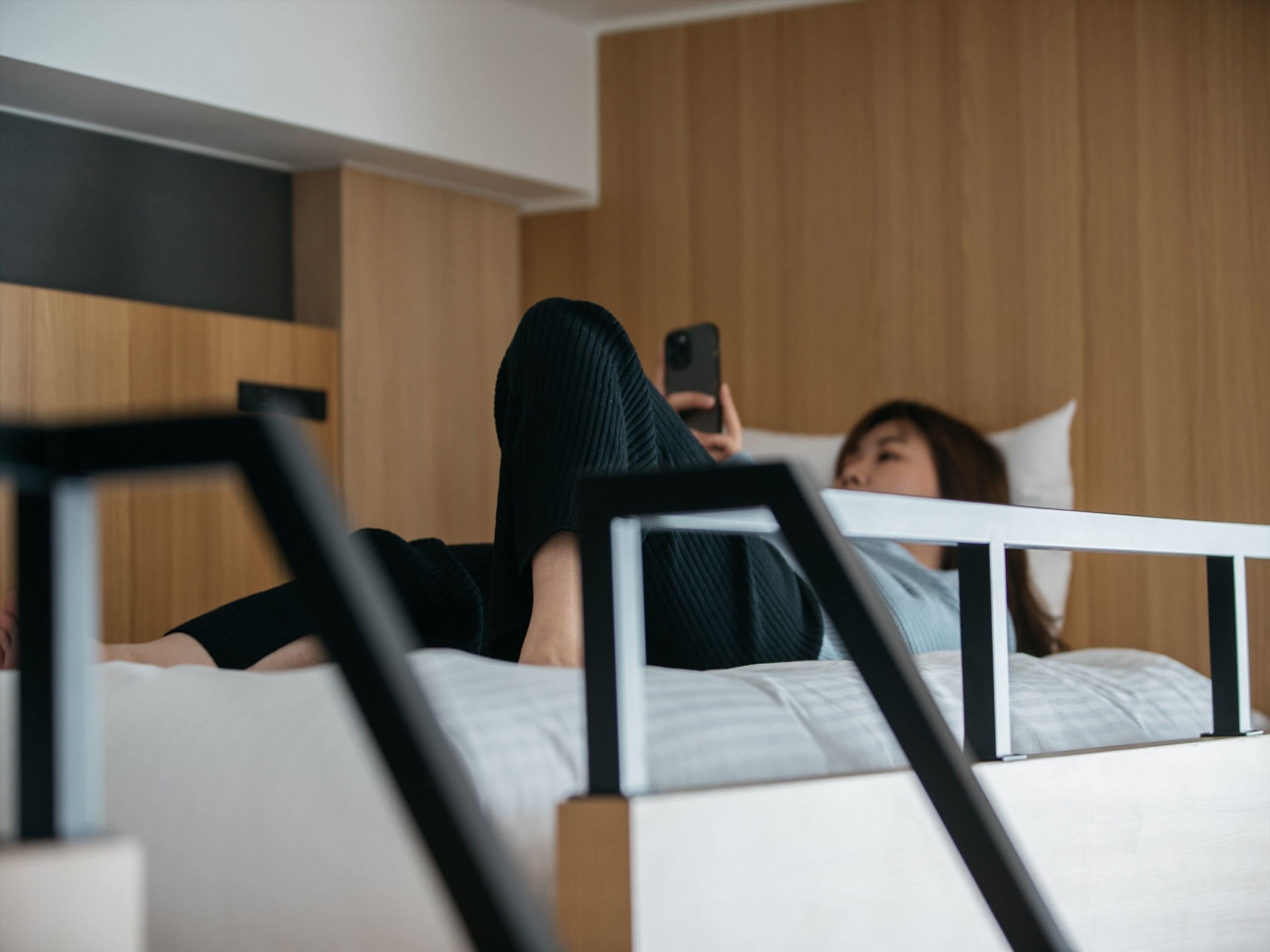 Een moderne slaapkamer met een bed, een houten hoofdbord en een witte nachtkastje.