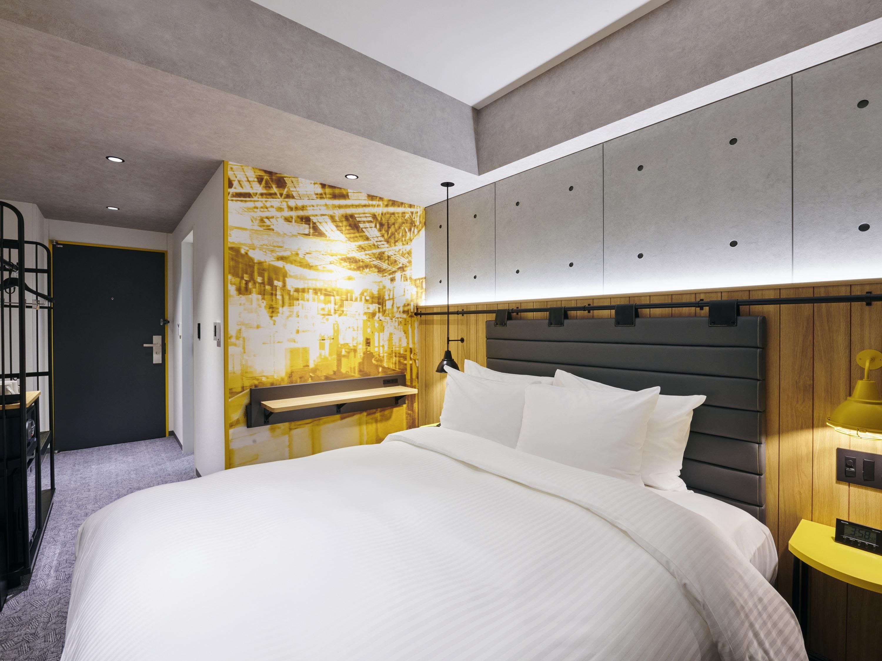 A modern bedroom with a large bed, built-in wardrobe, and a unique wall mural.