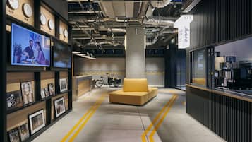 A modern interior with a sofa, a bicycle, and a wall-mounted TV.