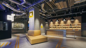 A modern interior with a sofa, a counter with various items, and a sign labeled "01". - ibis Styles Nagoya (Nagoya)