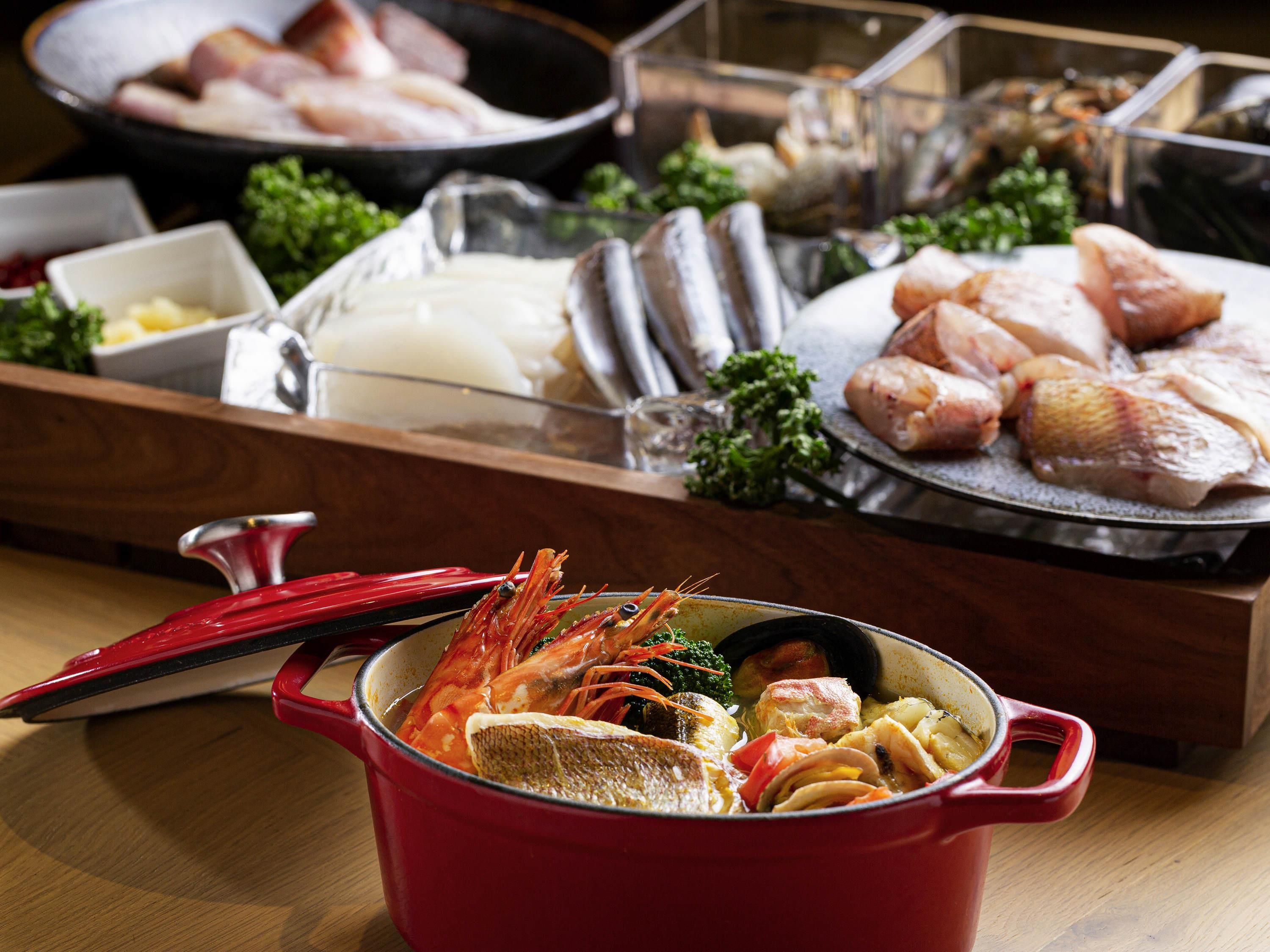 A variety of seafood and meats displayed on a wooden table.
