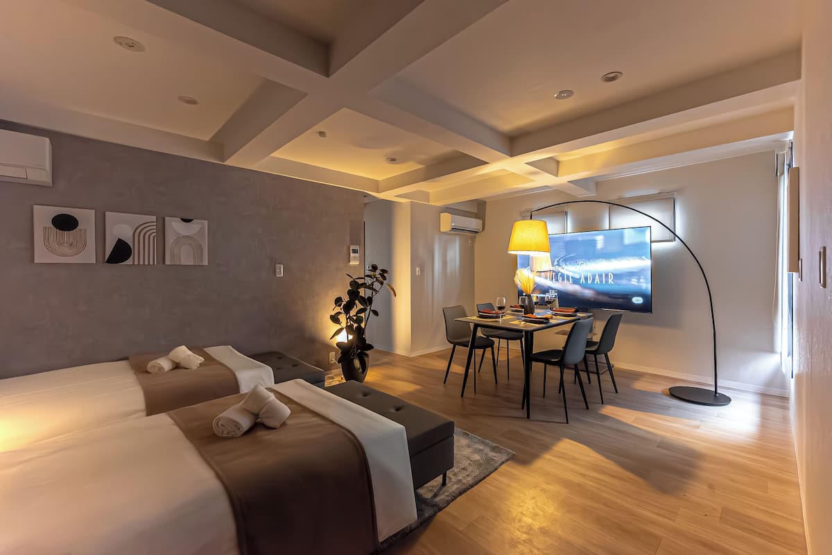 A modern hotel room with a large bed, a desk, and a flat-screen TV.