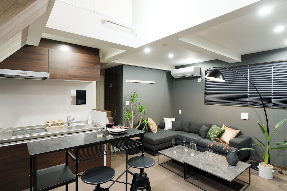 A modern kitchen with a dining area, a sofa, and a coffee table.