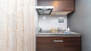 Een moderne keuken met donkere houten kastjes, roestvrijstalen apparatuur en een inbouwspoelbak.