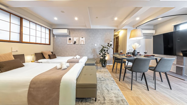 Een moderne hotelkamer met een groot bed, een bank, een zithoek en een televisie.