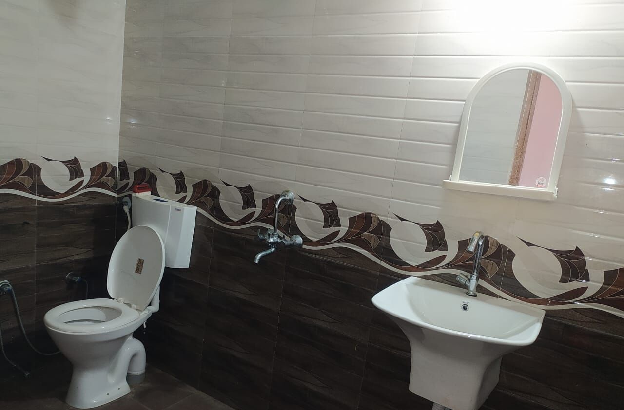 Un baño con inodoro, lavamanos y espejo.