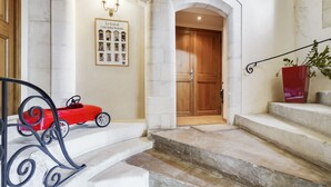 Un grand escalier orné d’une petite voiture rouge, d’une photographie encadrée représentant un festival et d’une plante en pot.