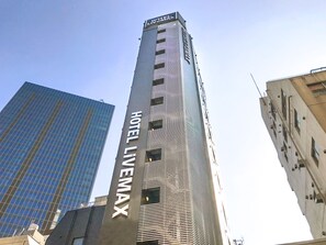Een hoog gebouw met het bord 'HOTEL LEMAX' op de gevel.