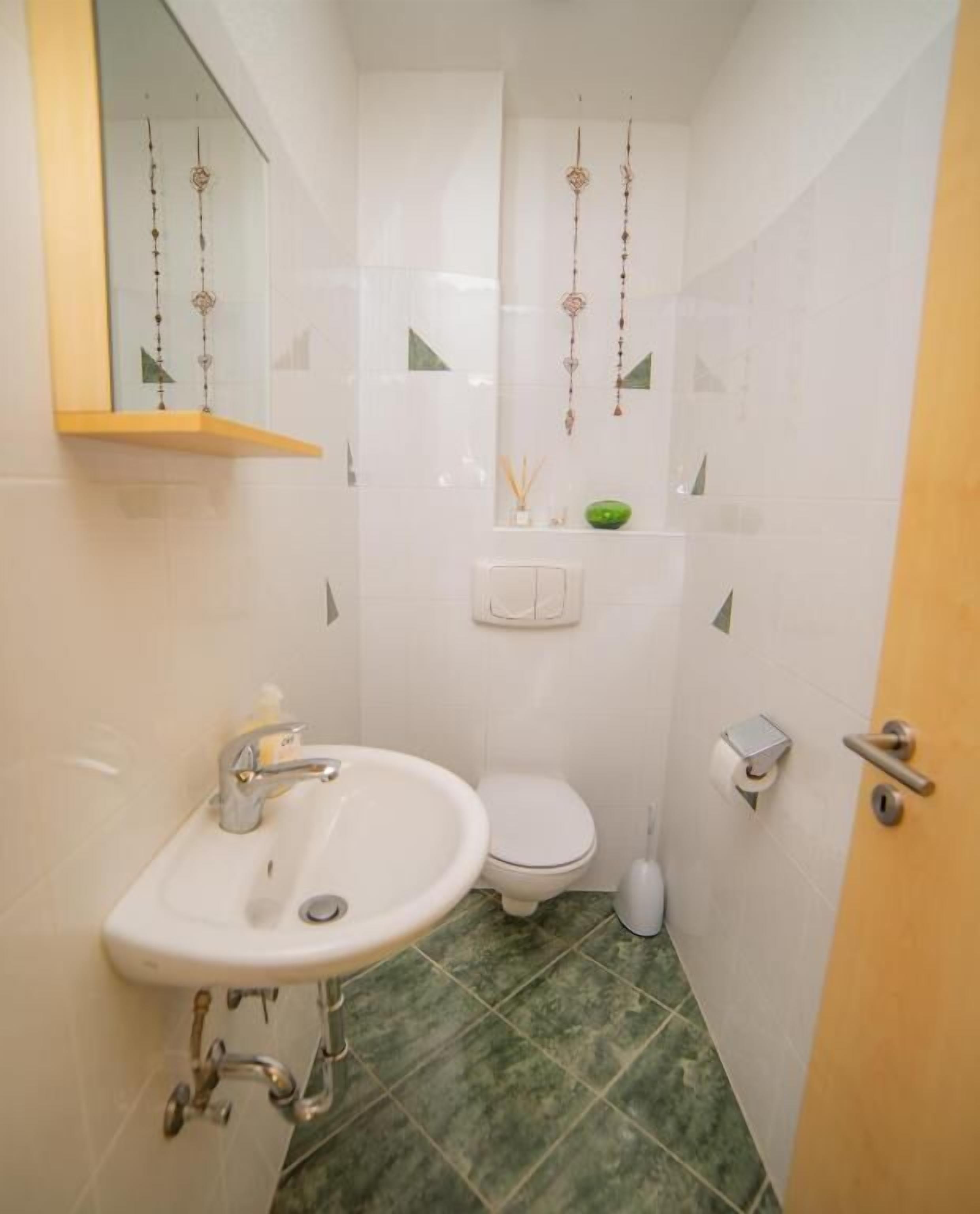 Une petite salle de bain avec un lavabo, des toilettes et un miroir.