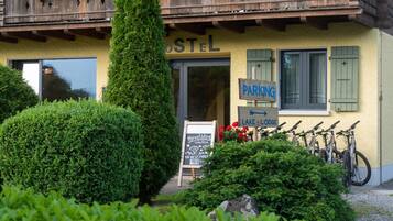 A building with a sign reading "OSTEL" and another sign indicating "PARKING" with arrows pointing to "LAKE" and "LODEGE".