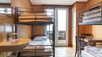 A bunk bed room with a sink and a table.