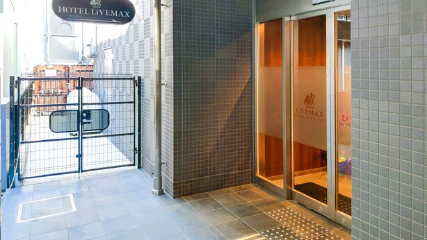 A hotel entrance with a tiled floor, a metal gate, and a sign reading "HOTEL LIVEMAX". - HOTEL LiVEMAX Tachikawa Ekimae (Tachikawa)