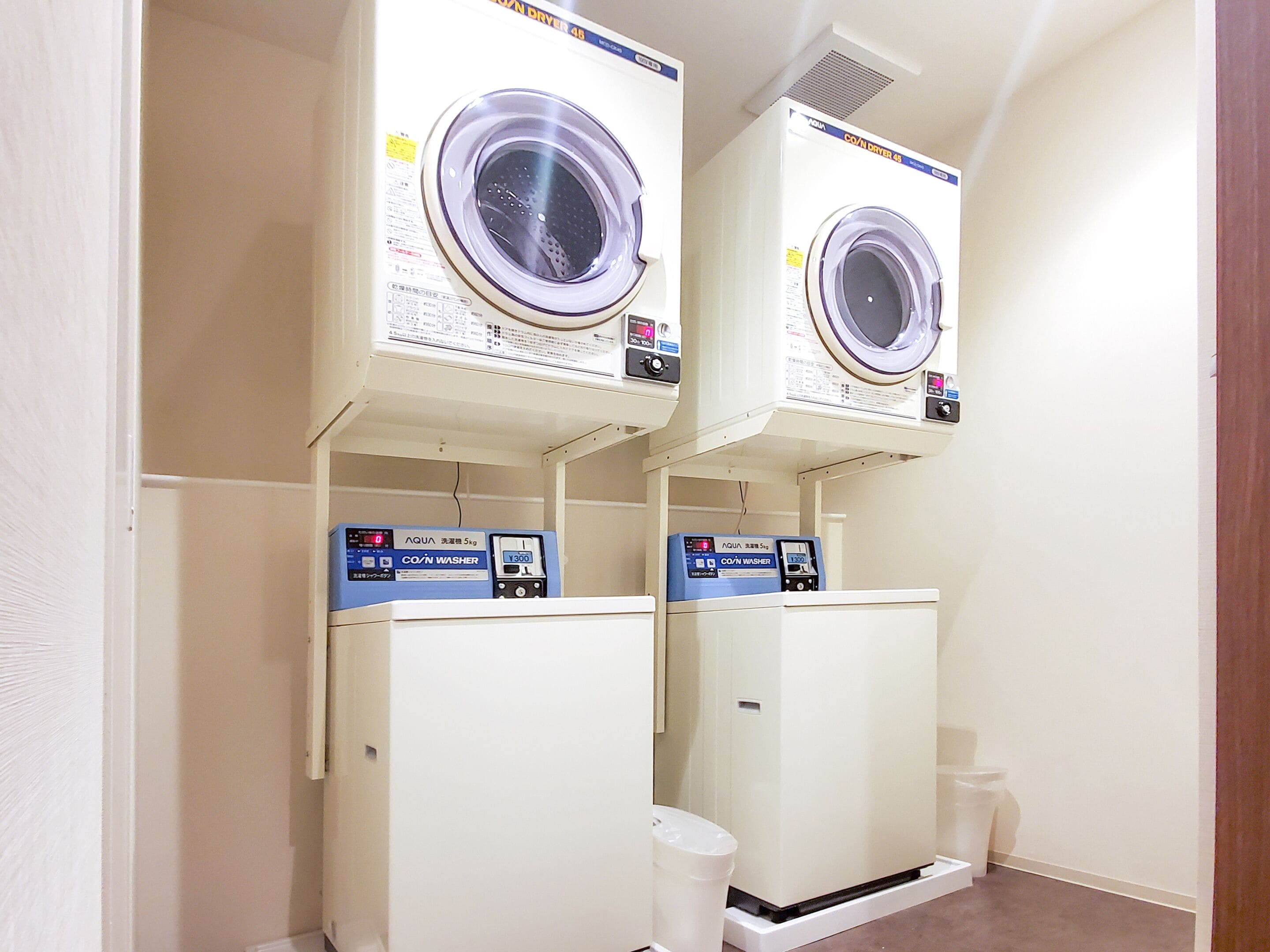 A laundry room with two stacked washing machines and a dryer.