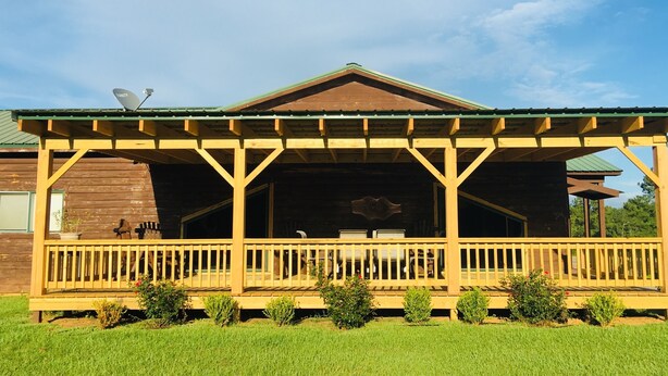 A wooden cabin with a porch, a satellite dish, and a green roof. - High Class Cabin Hideaway (Rutledge)