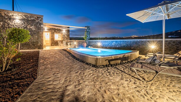 Un edificio de piedra con piscina, zona de estar al aire libre y vistas al paisaje.