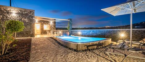 Alberca al aire libre, sombrillas en la alberca y camastros