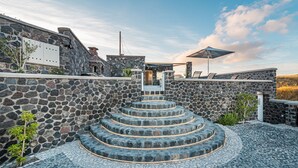 Una escalera de piedra que conduce a una zona cubierta con espacio para sentarse y vistas al cielo.