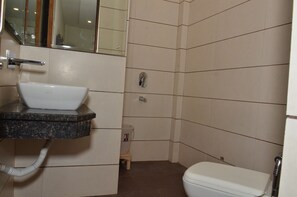 A bathroom with a sink, toilet, and mirror.