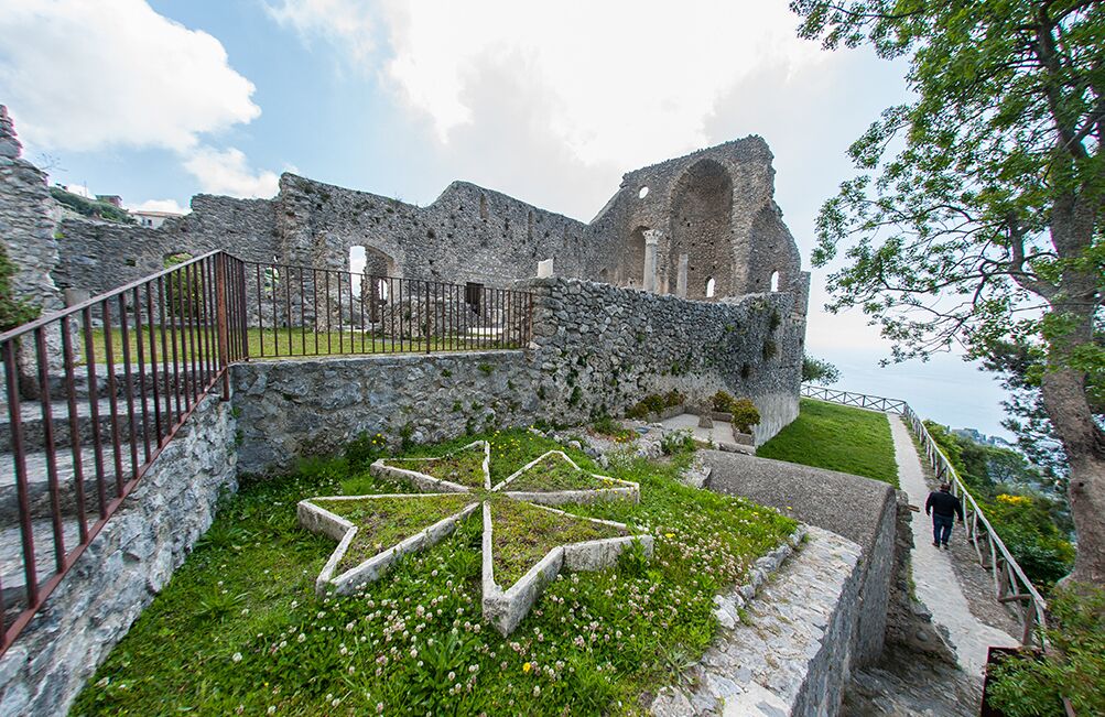 Una antigua estructura de piedra con un jardín en forma de estrella en primer plano.