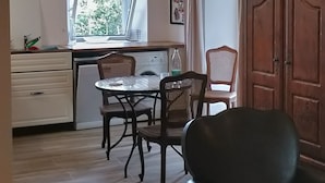 Una cocina moderna con zona de comedor, armarios de madera y un ventanal grande.